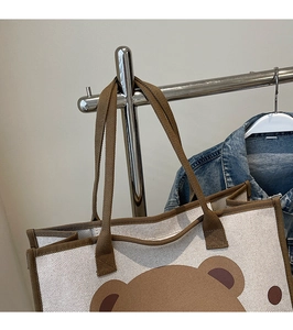 Détail du sac à langer en toile avec motif ours brun et sangles tissées résistantes
