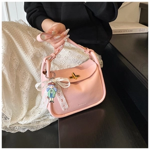 Pink lychee texture crossbody bag with gold twist lock and cute girl doll pendant charm