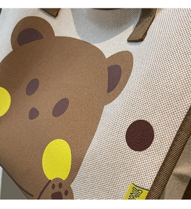 Vue détaillée du sac cabas tissé avec un motif d'ours brun et une étiquette en tissu