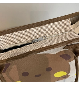 Gros plan du zip en métal et de l'imprimé ours sur le sac fourre-tout en toile
