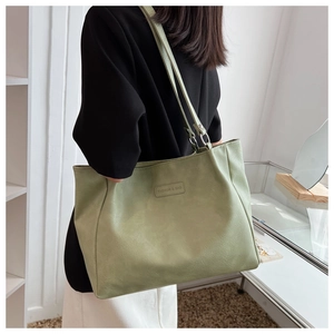 Detail of soft bean green PU leather tote bag featuring a Fashion & Bag embossed plaque