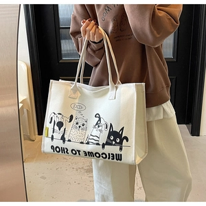 Detailansicht der weißen Canvas-Tasche mit schwarzen Comic-Tiermotiven und gelbem Etikett