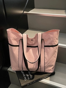 Pink large capacity tote bag with black handles and shoulder straps for daily commuting