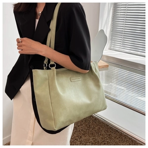 Detail view of light green tote bag with Fashion & Bag label on soft textured PU leather