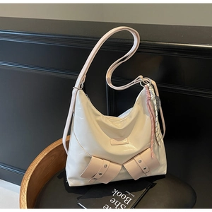 Détail du sac cabas crème avec poches avant roses et sangles décoratives à boucles