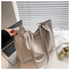 Close-up of white lychee leather tote bag with Fashion & Bag label on office desk