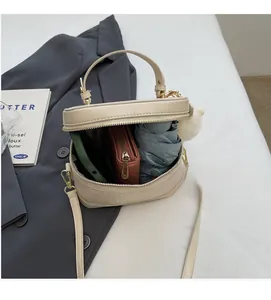 Détail de l'intérieur du mini sac beige montrant l'espace pour parapluie et mobile