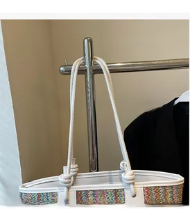Detail of colorful woven tote bag with white knotted leather handles and striped texture