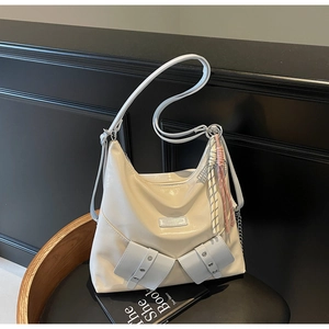 Détail du sac fourre-tout blanc cassé avec poches latérales et charme en corde tressée