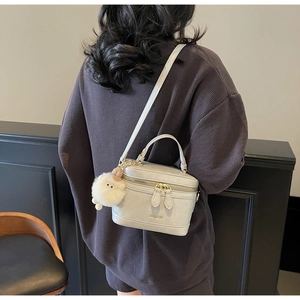 Détail du sac bandoulière gris avec poignée et charmant pendentif agneau en peluche
