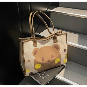 Détail du sac fourre-tout en toile épaisse avec un motif d'ours brun et une étiquette