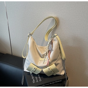 Détail du sac en cuir verni blanc crème avec lanières jaunes et pendentif raquette