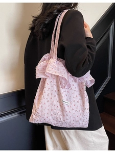 Pink floral tote bag with ruffle trim and Magic Pocket label shown on a model