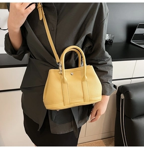 Detail der gelben Lychee-Ledertasche mit Metallschnalle im Büro-Ambiente