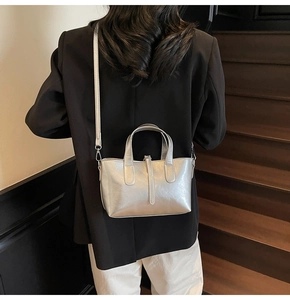 Silver metallic tote bag detail with minimalist vertical strap and detachable shoulder strap