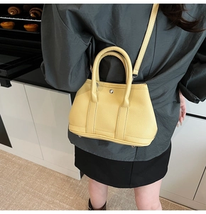 Detailansicht der gelben Ledertasche mit schützenden Boden-Nieten und Leder-Struktur
