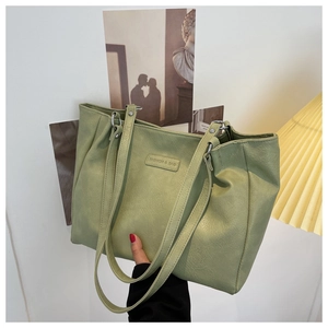 Close-up of light green tote bag with premium leather texture and fashion brand tag
