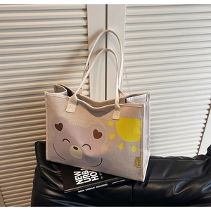 Détail du sac fourre-tout en toile beige avec ours de dessin animé sur fond en bois