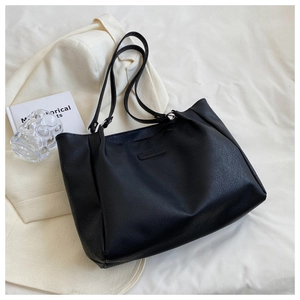 Close-up of black textured tote bag with Fashion & Bag logo on a cream fabric base