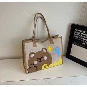 Détail du fourre-tout tissé beige avec motif d'ours et bordures brunes solides