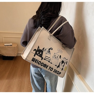 Detailaufnahme der beigen Canvas-Tragetasche mit Cartoon-Hunden und gelbem Etikett