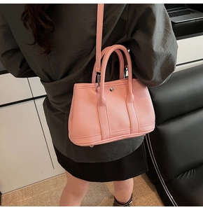 Detail der rosa Bucket-Bag aus Leder mit silbernen Beschlägen und Umhängeriemen