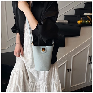 Nahaufnahme der hellblauen Eimer-Tasche aus genarbtem Leder mit goldener Schnalle
