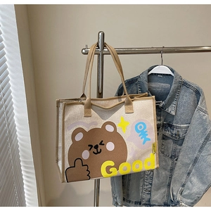 Détail du sac cabas en toile avec motif d'ours brun et poignée tissée robuste