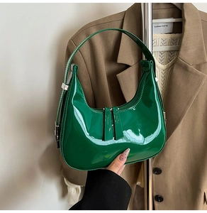 Détails de la surface en cuir verni vert brillant et de la fermeture éclair argentée du sac