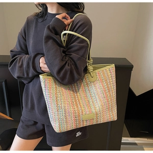 Detail of colorful woven tote bag featuring zigzag stripes and light green handles