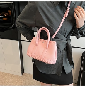 Detail der rosa Handtasche aus Kieselleder mit Rundgriffen und silbernen Metallbeschlägen