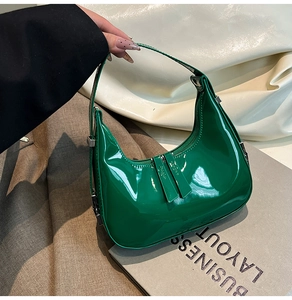 Détail du sac croissant en cuir verni vert avec finition brillante et fermoir argenté