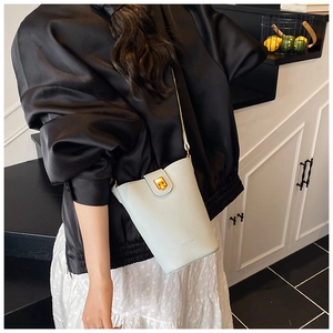 Nahaufnahme der hellblauen Eimer-Tasche mit goldenem Drehverschluss und HOCOMI-Logo