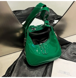 Détail du sac demi-lune en cuir verni vert brillant avec fermeture éclair argentée
