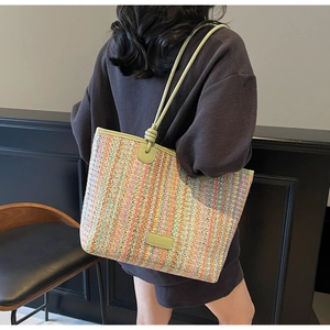 Detail of colorful striped woven tote bag with green leather shoulder strap and knot