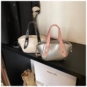 Detail showing two-tone mini crossbody bags in cream and silver with detachable straps