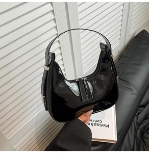 Gros plan d'un sac baguette en cuir verni noir brillant avec une finition miroir chic