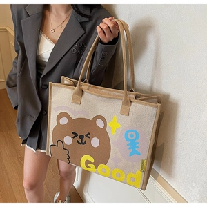 Détail d'un sac fourre-tout en toile beige avec imprimé ours et anses kaki