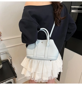 Detail einer hellblauen Eimer-Tasche aus strukturiertem Leder mit silberner Schnalle