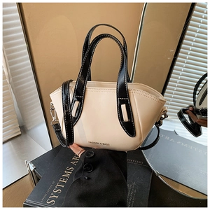 Detailed view of cream and black contrast pillow bag with silver hardware and logo