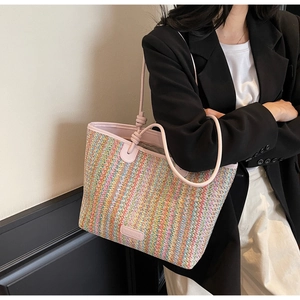 Detail of colorful striped woven tote bag with pink leather strap and decorative knots