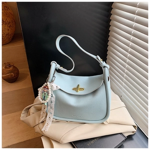 Makroaufnahme der hellblauen Tasche aus genarbtem Leder mit goldenem Drehverschluss