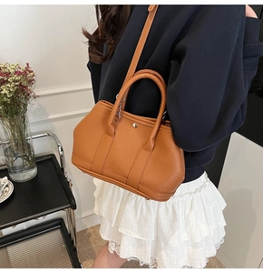 Detailansicht der braunen Bucket Bag aus Litschi-Leder mit silbernen Beschlägen und Griff