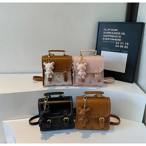 Detail von vier Mini-Crossbody-Taschen aus Leder mit Bärchen-Anhängern und Griffen