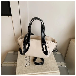 Detail of color-block pillow bag featuring Fashion & Bags logo and silver hardware