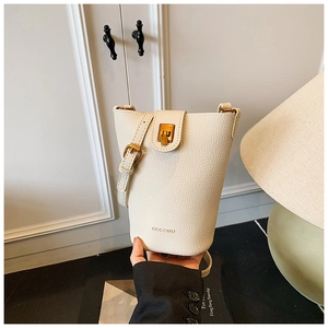 Nahaufnahme der cremefarbenen Beuteltasche mit Lychee-Ledertextur und goldener Schnalle
