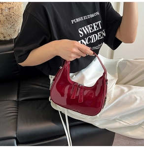 Vue détaillée du sac à main croissant en cuir verni rouge foncé à double zip