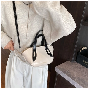 Detail of minimalist cream crossbody bag with black trim and FASHION & BAGS text