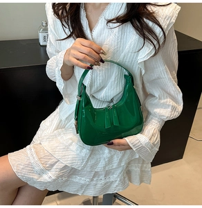 Détail du sac demi-lune en cuir verni vert avec double fermeture éclair et poignée