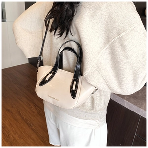 Detail view of contrast color crossbody pillow bag with adjustable shoulder strap